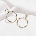 Boucles d'oreilles clips créoles dorées torsadées pour oreilles non percées sur fond soie. - Boucles d'Oreilles à Clip (662) / Or
