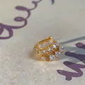 Λεπτομερής όψη επίχρυσου σκουλαρικιού ear cuff με λαμπερά στρογγυλά ζιργκόν. - Μονό κλιπ αυτιού / Χρυσό