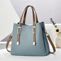 Elegante staubblaue Handtasche aus Kunstleder mit kontrastierenden braunen Henkeln - Blau