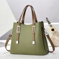 Elegante grüne Handtasche aus Kunstleder mit braunen Riemen und Metallteilen - Grün