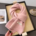 Nahaufnahme eines rosa Strickschals mit einem deutlichen WOOL BLEND Textiletikett am Rand - 164x22cm / Rosa (WT282-9)