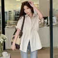 Elegant beige short-sleeved shirt for women with a flattering gathered waist design. - Apricot