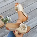 Close-up of elegant gold floral slide sandals for women with open-toe design - Gold