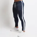 Men's slim-fit navy blue joggers featuring a contrasting white side stripe detail. - M / Bottoms / Navy Blue