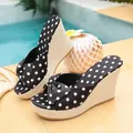Close-up of black polka dot wedge sandals with decorative bow and woven straw platform - 35 / Black