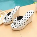Detailed view of stylish white polka dot wedge sandals featuring straw base and decorative bow - 35 / Off White