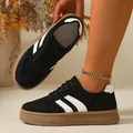 Close-up detail of retro black suede sneakers with white stripes and thick gum soles - 36 / Black