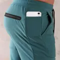 Close-up detail of teal sports sweatpants with a dedicated smartphone pocket for gym - M / Bottoms / Lake Blue