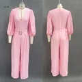 Front and back detail view of a pink deep V-neck puff sleeve wide-leg jumpsuit - S / Pink