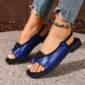 Elegant blue square-toe slingback flat sandals for women displayed on a textured grey rug. - Dark Blue
