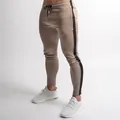 Detailed view of khaki slim-fit joggers with black side stripe on male fitness model - M / Bottoms / Khaki