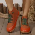 Detailansicht von modischen High-Top-Sneakern für Damen mit grünen Schnürsenkeln. - Orange