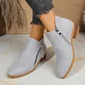 Detailed macro view of light grey suede ankle boots featuring stylish double side zippers - Light Gray