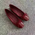Detail view of red patent leather ballet flats with square toe and bow decoration. - 35 / Burgundy