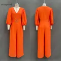Front and back views of a vibrant orange-red deep V-neck loose jumpsuit with puff sleeves - S / Orange Red