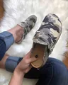 Primo piano di sabot da donna con motivo mimetico e bordi sfrangiati su un tappeto bianco. - 36 / Mimetico