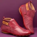Detailed macro view of vintage red PU leather flat ankle boots featuring velcro strap - 35 / Red