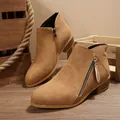 Macro view of tan suede pointed toe ankle boots featuring side zipper and block heel - Dark Brown