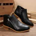Detail view of black pointed-toe ankle boots featuring low chunky heels and zippers. - 36 / Black