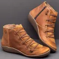 Gros plan de bottines en cuir marron avec sangles croisées et fermeture éclair latérale - Marron