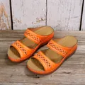 Close-up of vibrant orange wedge sandals featuring intricate decorative cutout patterns - 36 / Orange