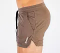 Side view detail showing the mesh texture and logo of brown quick-dry sports shorts for men - Khaki