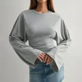 Detailansicht eines grauen Langarmshirts mit weiten Ärmeln und tailliertem Schnitt. - XS / Oberteil (Große Manschette) / Grau