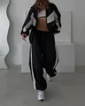 Full shot of a stylish black and white color-block tracksuit set with a zip-up jacket. - S / Top And Bottom / Black