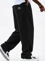 Detailed view of men's black wide-leg corduroy pants with vertical ribbed texture - Black