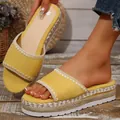 Detailopname van gele plateau-sleehaksandalen met decoratieve vlecht van henneptouw - Geel
