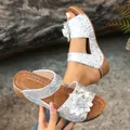 Detailansicht der silbernen Glitzer-Keilsandalen mit Blume und strukturierter Sohle - 36 / Silber