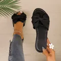 Macro view of stylish black flat slide sandals with a large decorative bow detail - 36 / Black