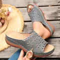 Close-up detail of women's grey wedge sandals featuring elegant laser-cut floral patterns. - 38 / Gray