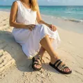 Lifestyle view of women's flat beach sandals with black and gold color-block straps - 36 / Black