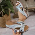 Vue détaillée de sandales compensées bleu clair avec fleurs et perforations. - 38 / Gris