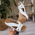 Vue détaillée des sandales compensées blanches vintage avec fleurs et détails découpés. - 36 / Blanc