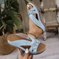 Gros plan de sandales compensées bleues avec fleurs et découpes dans un décor rustique. - 36 / Bleu ciel