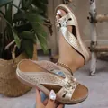 Vue détaillée des sandales à talons compensés dorées avec fleurs et motifs découpés - Champagne