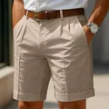 Detailed macro view of khaki pleated business casual shorts for men featuring a cuffed hem - S / Bottoms / Khaki