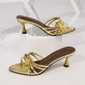Eleganti sandali dorati con tacco alto caratterizzati da fiore in metallo e cinturini. - 35 / Stile Tacco Basso / Oro