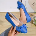 Detailed view of blue French pointed-toe flats with bow decoration and metal accents - Blue