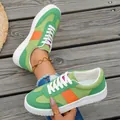 Detailed view of green and orange low-top casual sneakers on wooden deck background. - 36 / Green