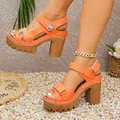 Detailansicht der leuchtend orangefarbenen Plateausandalen mit Blockabsatz und Nähten - 36 / Orange