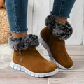 Detail view of brown suede women's snow boots with grey faux fur trim and white sole. - Brown