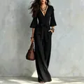 Detail showing the elegant black deep V-neck jumpsuit with bell sleeves and textured fabric - S / Set / Black