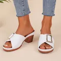 Elegante witte muiltjes met blokhak, decoratieve gesp en stijlvolle houtlook hak. - Wit