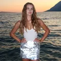 Detail of a sexy silver large paillette sequin bodycon mini skirt worn at sunset - S / Bottoms / White