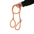 Hand holding a bright orange heavy-duty braided slip lead dog leash detail view. - Orange