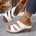 Detailweergave van witte sleehaksandalen met elegante uitgesneden bandjes. - Wit