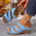 Detailed view of blue wedge sandals with Velcro straps on a foot and held by hand. - 36 / Sky Blue